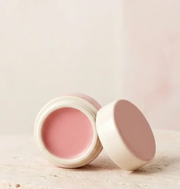 petal-lip-balm Pink lip balm in an ivory pot with a blush lid.