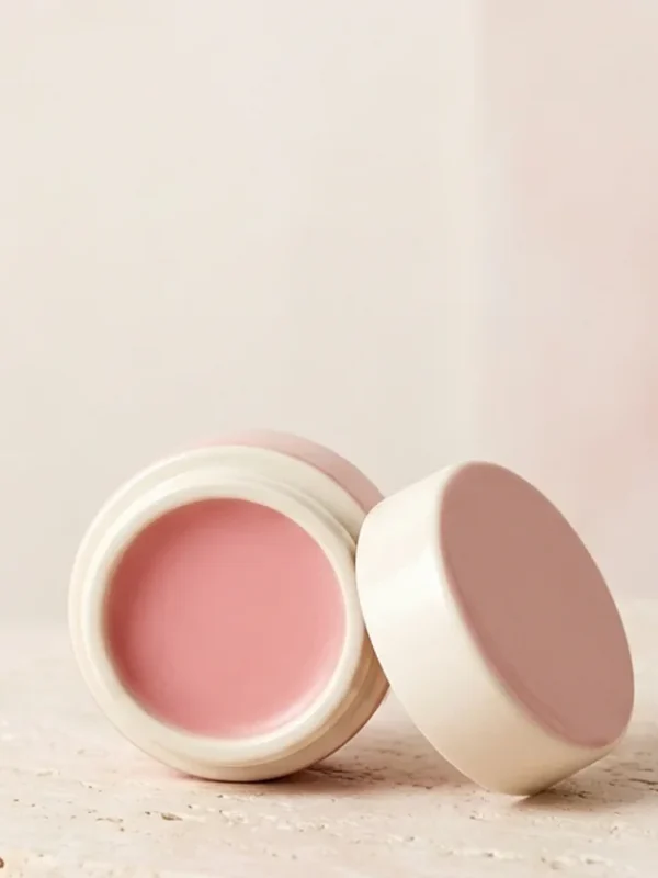 petal-lip-balm Pink lip balm in an ivory pot with a blush lid.