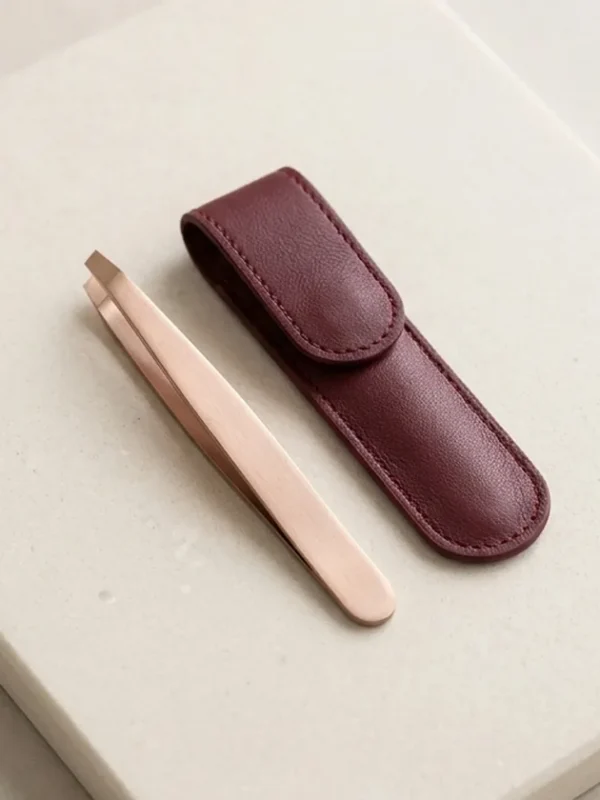 Rose Gold Slant Tweezers with Case Rose-gold slant-tip tweezers beside a burgundy protective case.